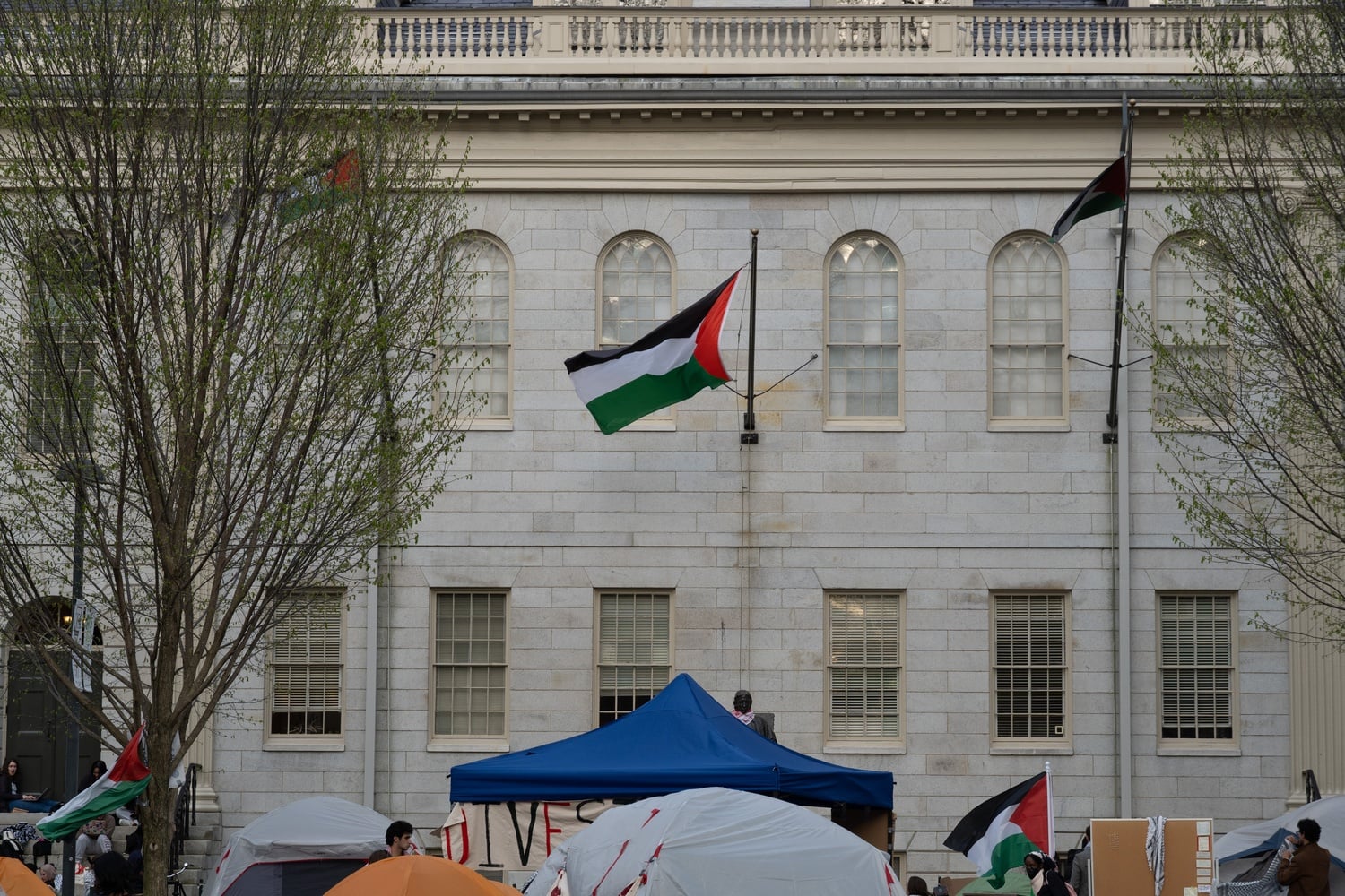 Three Palestinian flags were raised above University Hall on Saturday on the fourth day of the pro-Palestine Harvard Yard encampment before Harvard police officers removed it about one hour later.