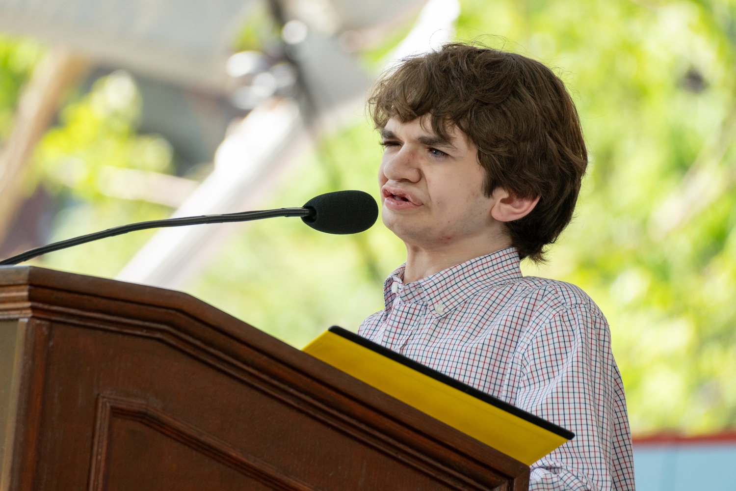 Ben T. Elwy '23-'24, the Harvard Orator for the Class of 2024, delivers their address at the Class Day ceremony.
