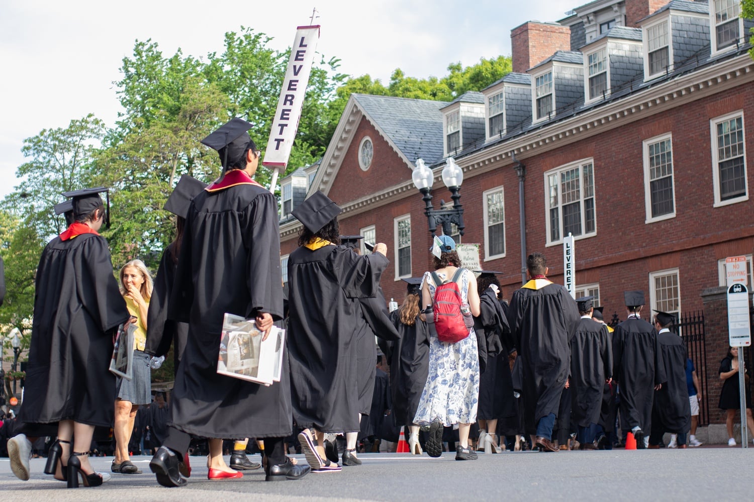 Graduates in Leverett House process down Mass. Avenue along Harvard Yard.