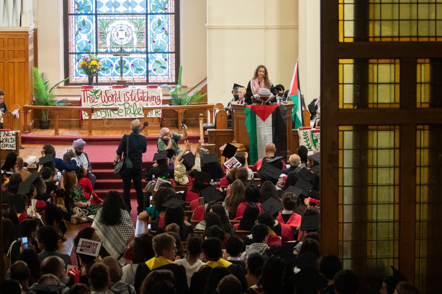Pro-Palestine protesters cheer inside Harvard Epworth Church Thursday during HOOP’s “People’s Commencement.”