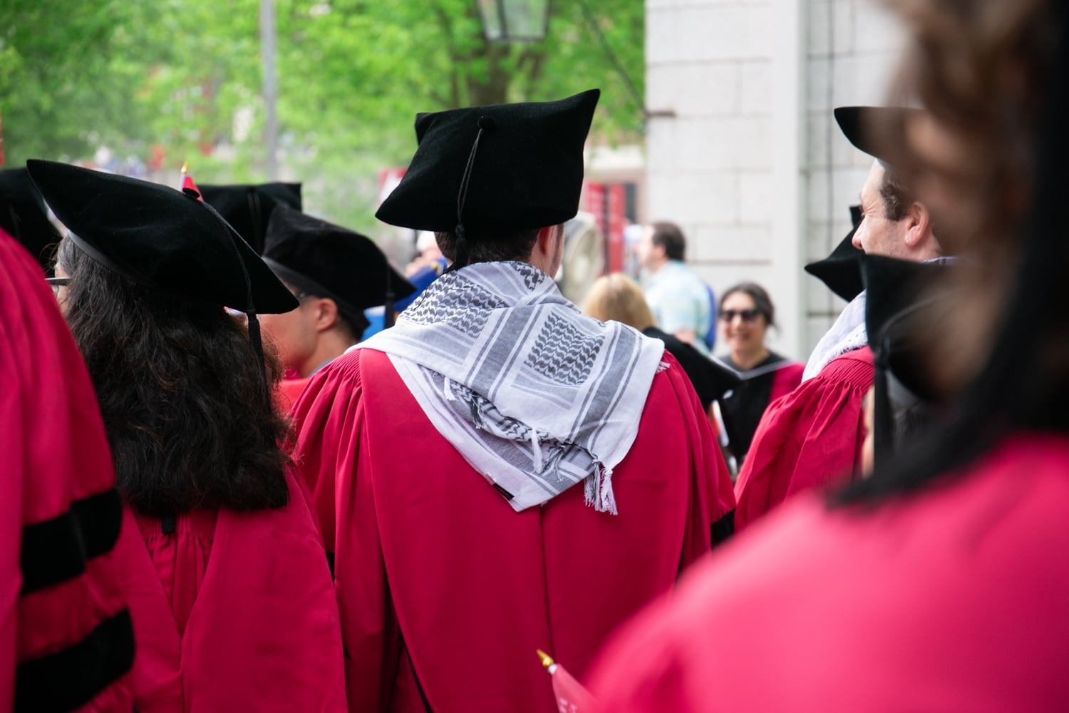 A graduate wearing a keffiyeh stands at Commencement Thursday morning.
