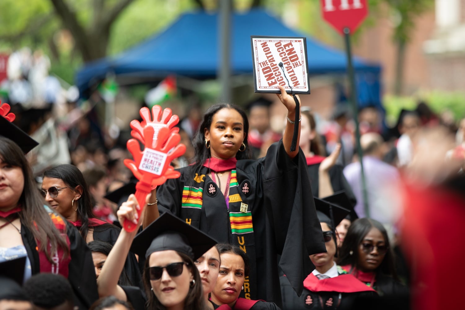 A female student holds up a graduation cap with the message "End the Occupation" during Harvard's Commencement ceremonies Thursday.