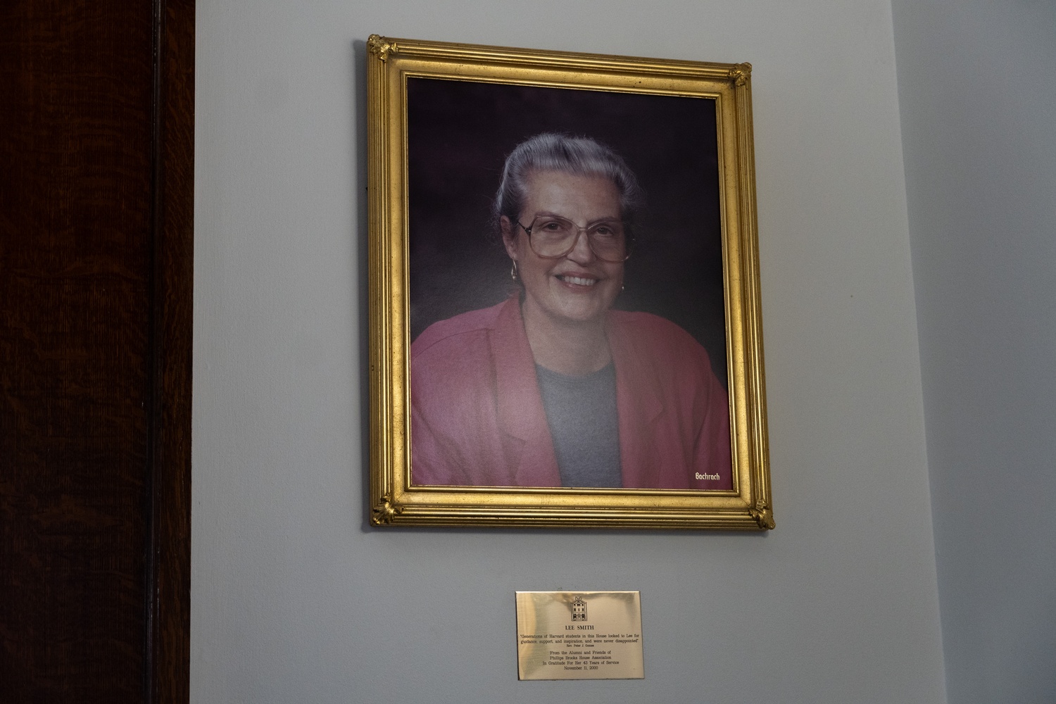 A portrait of Lee H. Smith, a longtime staff member, hangs on a wall inside the Phillips Brooks House in Harvard Yard. Smith died in June at the age of 89.