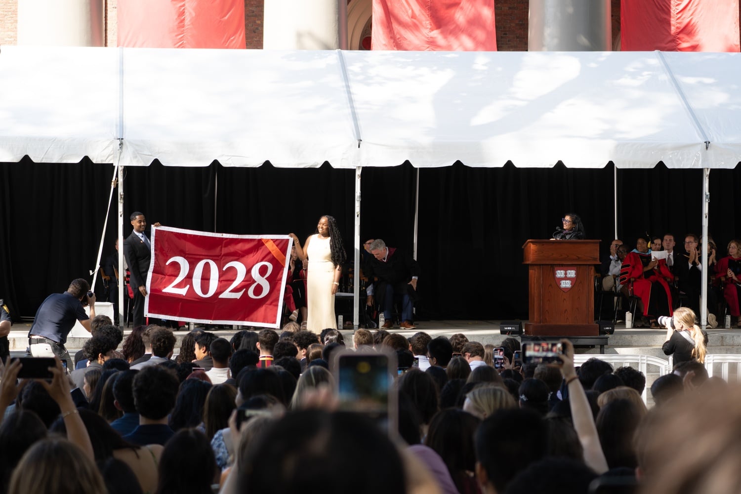 The Harvard Undergraduate Association co-presidents Ashley C. Adirika '26 and Jonathan Haileselassie '26 unveil the class banner at the Class of 2028 Convocation.