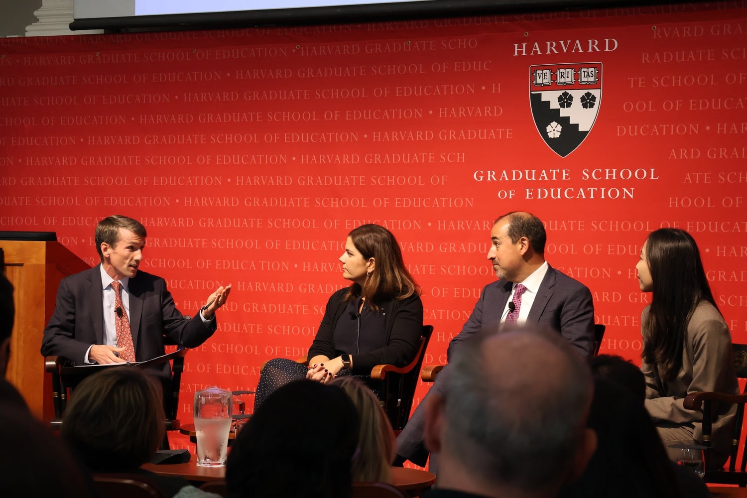 Martin West, the event's moderator, seated next to Marta McAlister, Roberto J. Rodríguez, and Ying Xu.