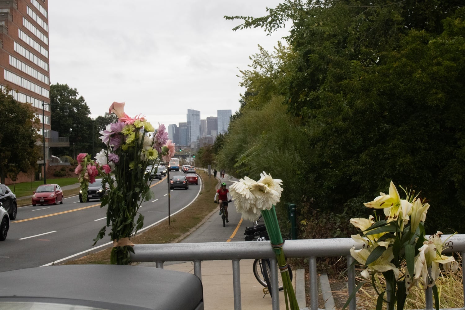 Bikers and drivers passed by flowers tied to a fence Wednesday.