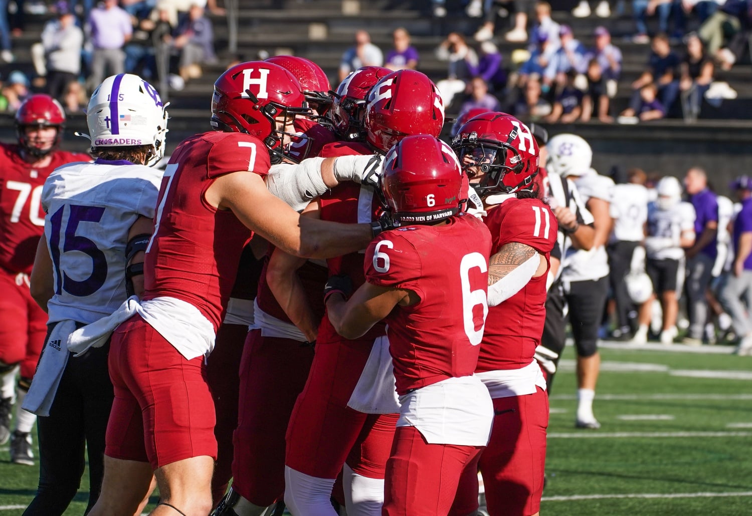 Harvard’s football team celebrates after Junior wide receiver Cooper Barkate scores a touchdown against Holy Cross.