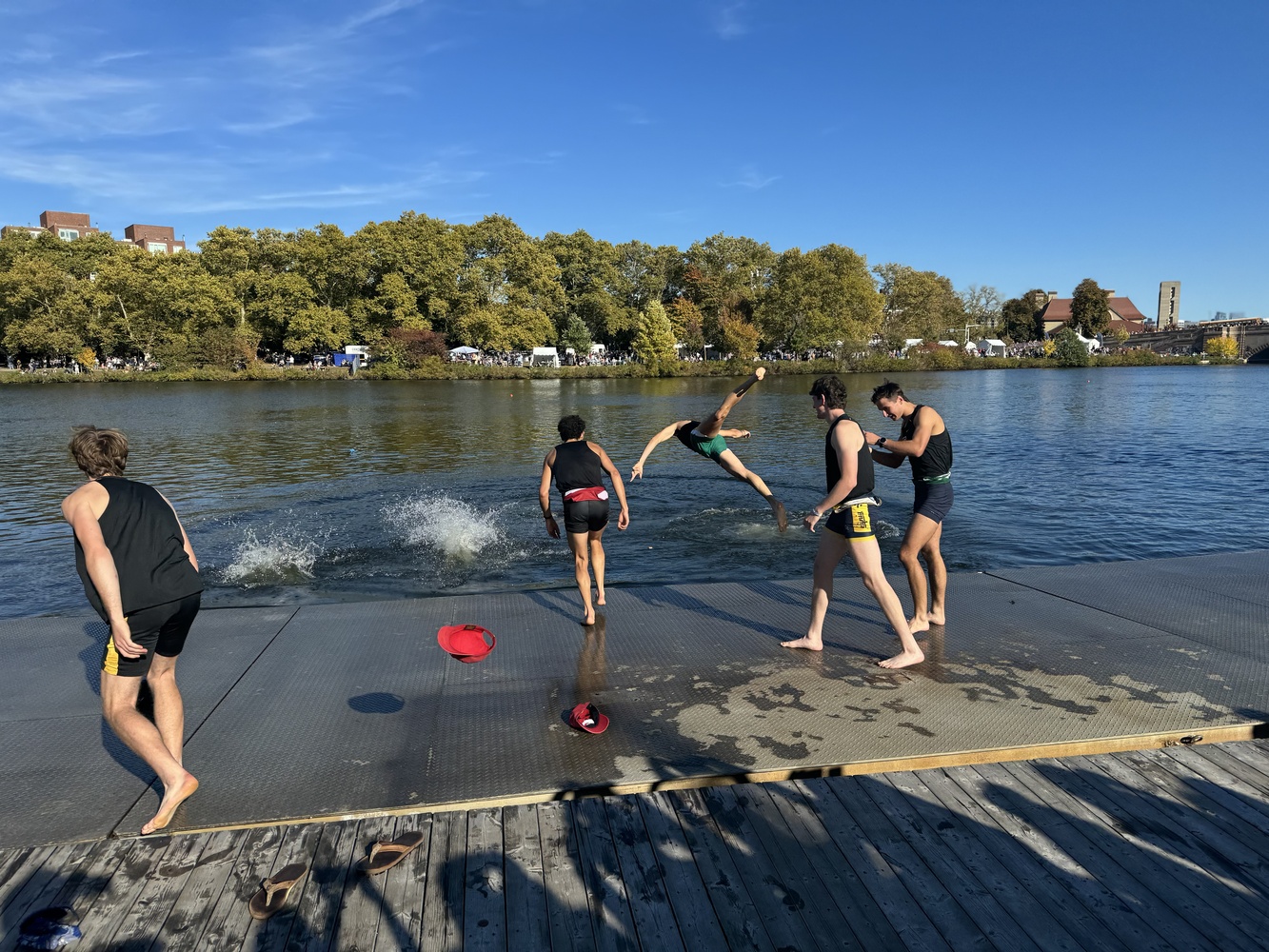 The men's lightweight eight rowers catapult themselves into the Charles, after their third consecutive victory at Head of the Charles.