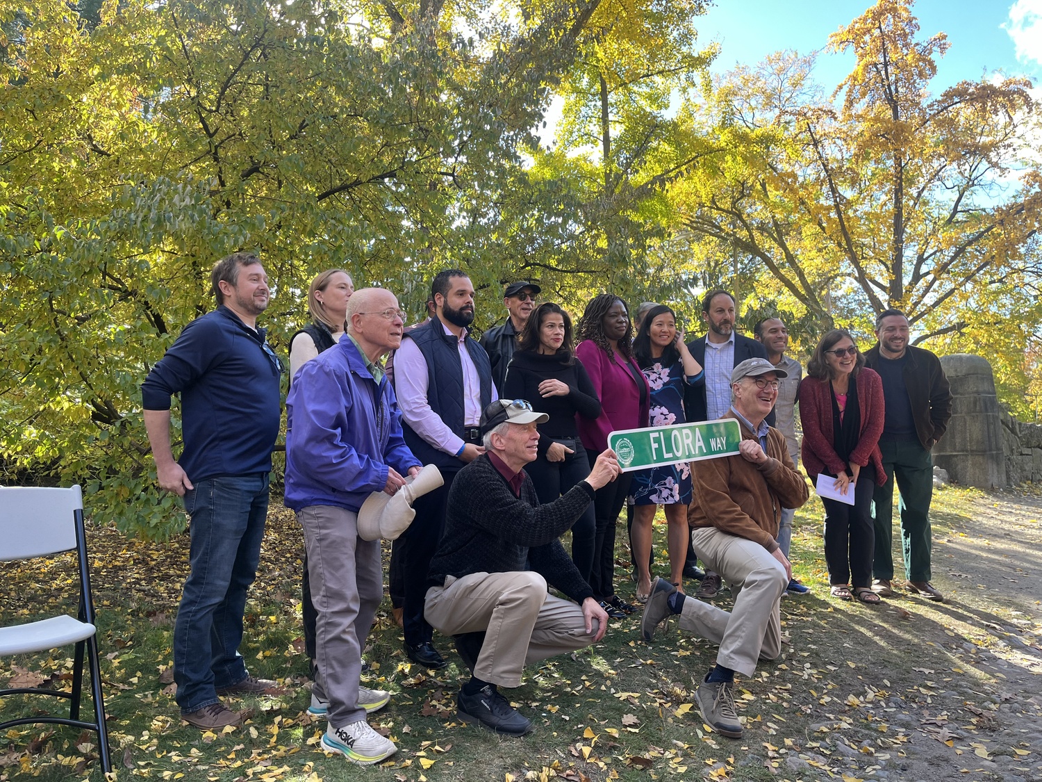 Dedication attendees pose with the new Flora Way street sign.