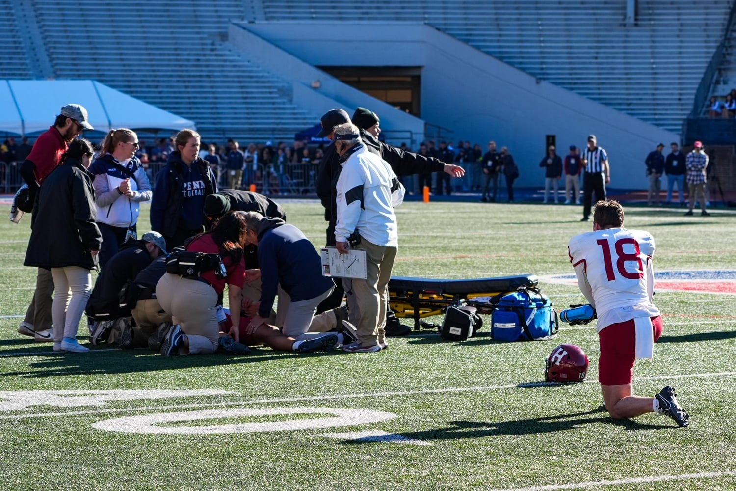 Junior wide receiver Cooper Barkate kneels on the field as he watches his roommate, quarterback Jaden Craig, receive medical attention after a scary hit.