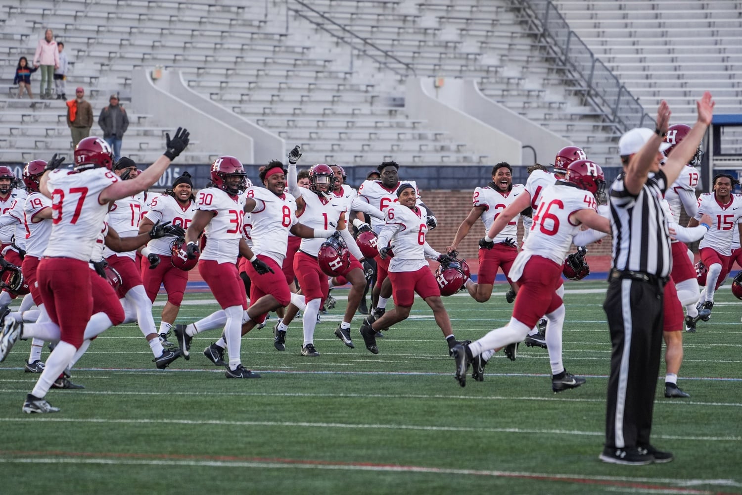 The whole Crimson team rushes onto the field to celebrate their victory against Penn, which also secured Harvard a share of the Ivy League title.