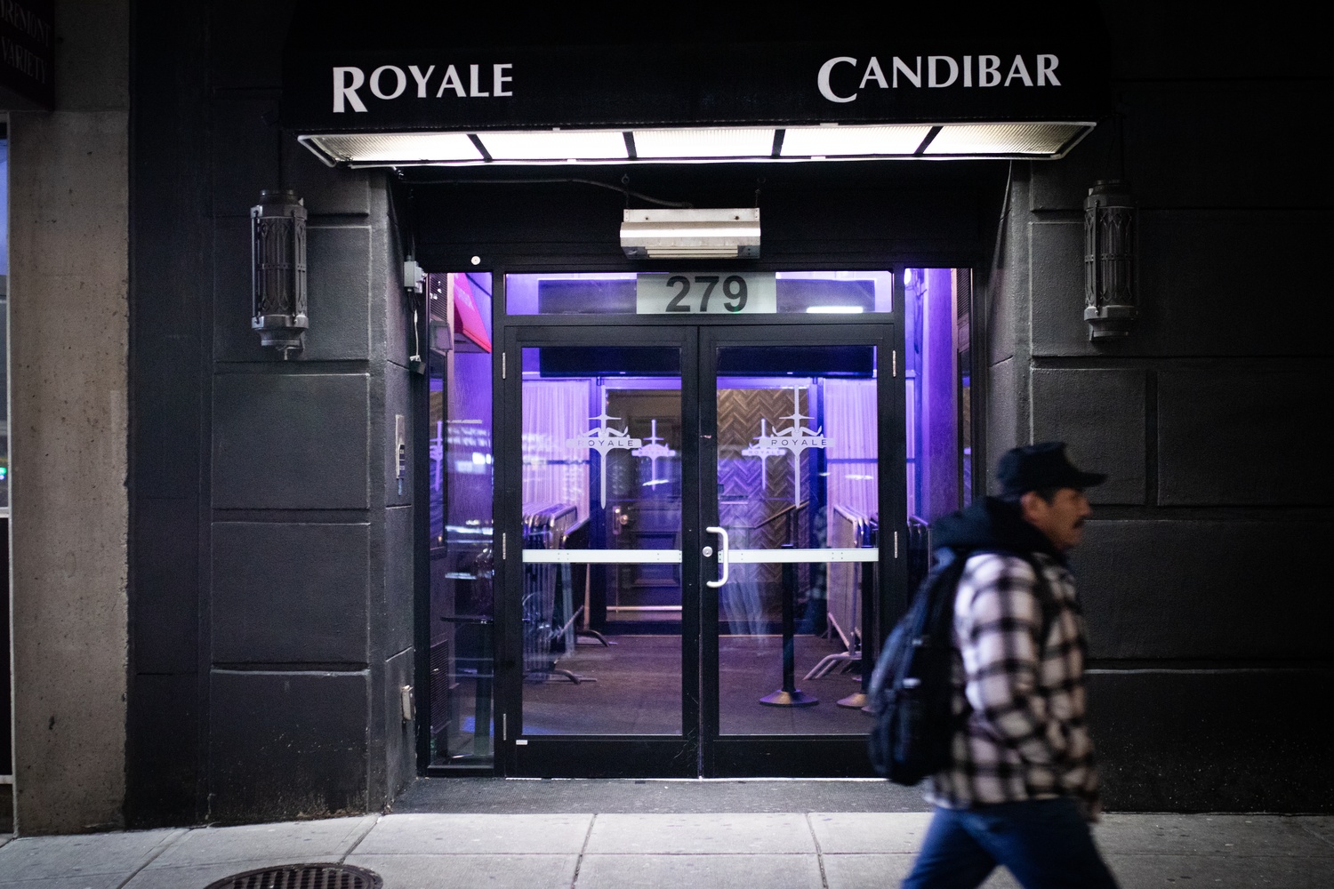 A passerby walks past Royale Nightclub around midnight last Monday.