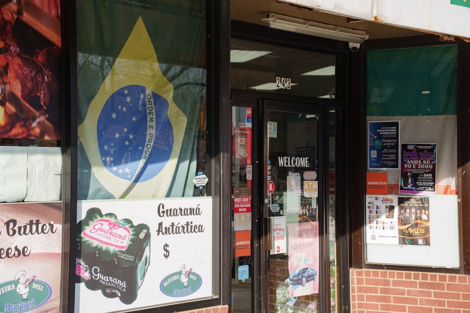 Anúncios e cartazes em português preenchem o batente de um mercado brasileiro em Brighton, que oferece produtos e refeições típicas do país.