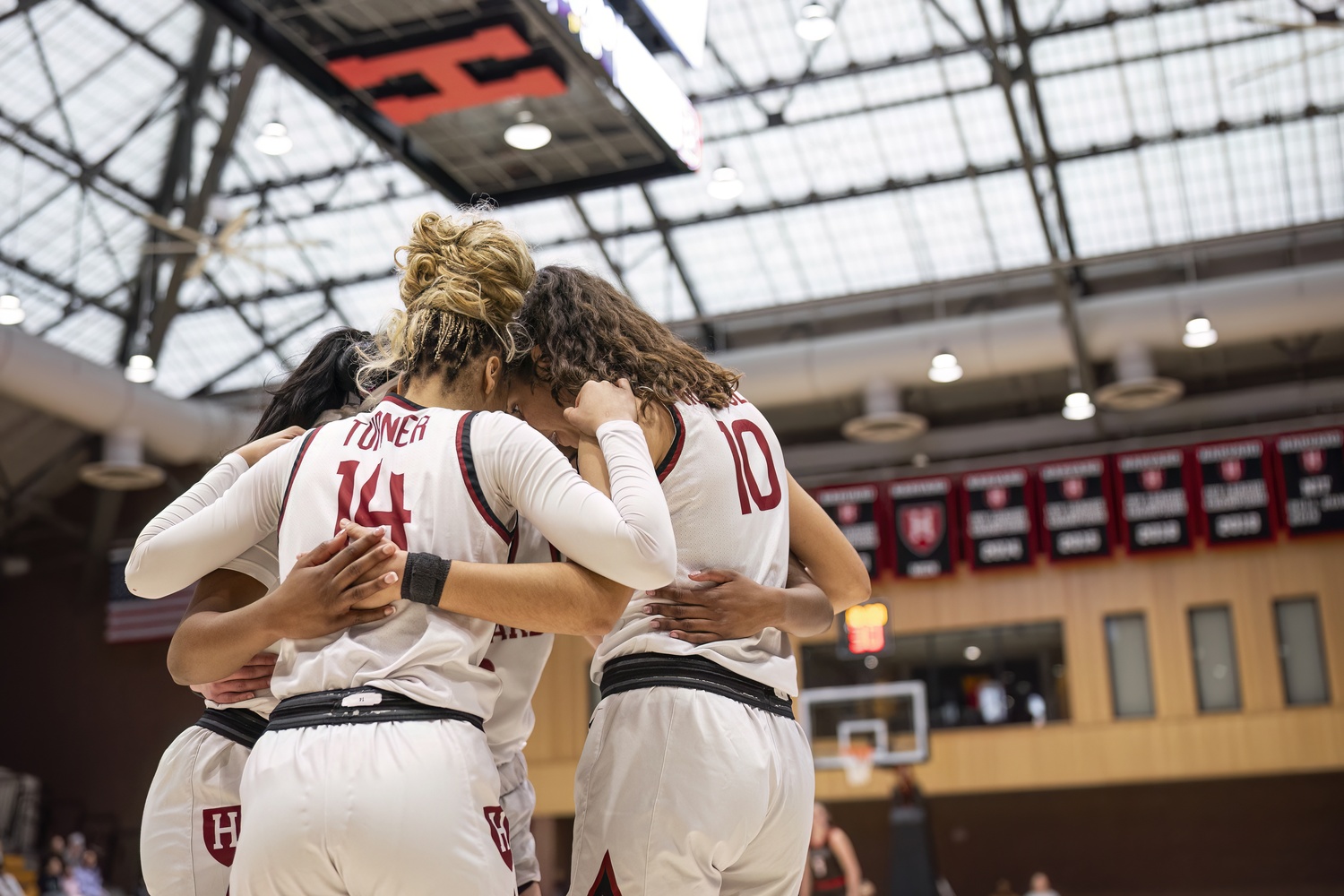 Senior Harmoni Turner huddles Crimson teammates. Turner was key in securing the dual Harvard victories over the weekend.