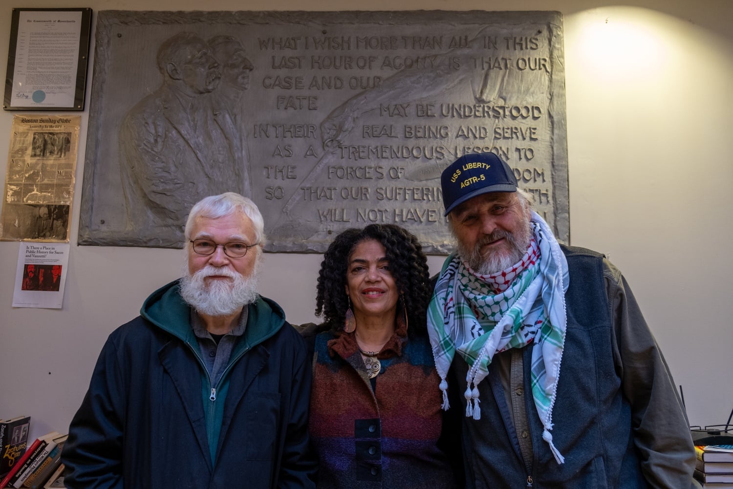 Kaplan, Christle Rawlins-Jackson — the Church's Office and Publications Manager — and Stevens in front of a plaque of Sacco and Vanzetti.