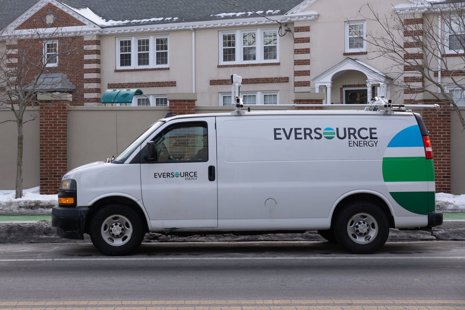 An Eversource Energy van sits on the side of a street in Cambridge. On Monday, the company proposed 10 percent cuts to gas bill delivery rates.