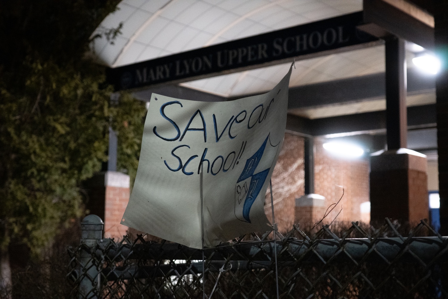 Parents and faculty protest the proposed closures of schools prior to a meeting at Mary Lyon Pilot High School Tuesday evening.