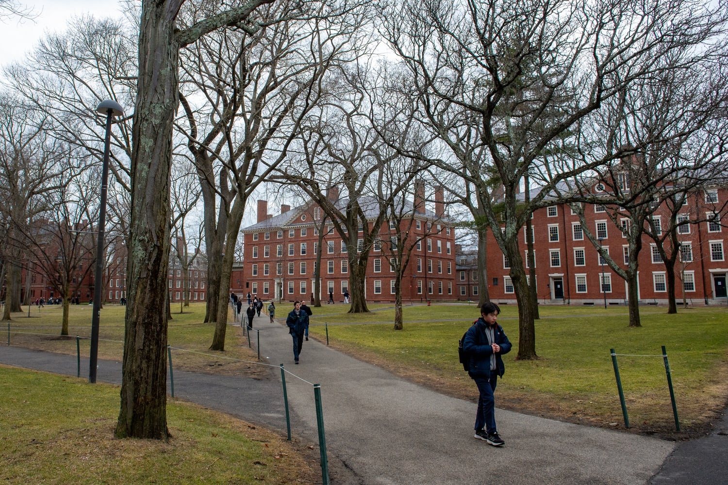 Students walk through Harvard Yard on a rainy day in March.