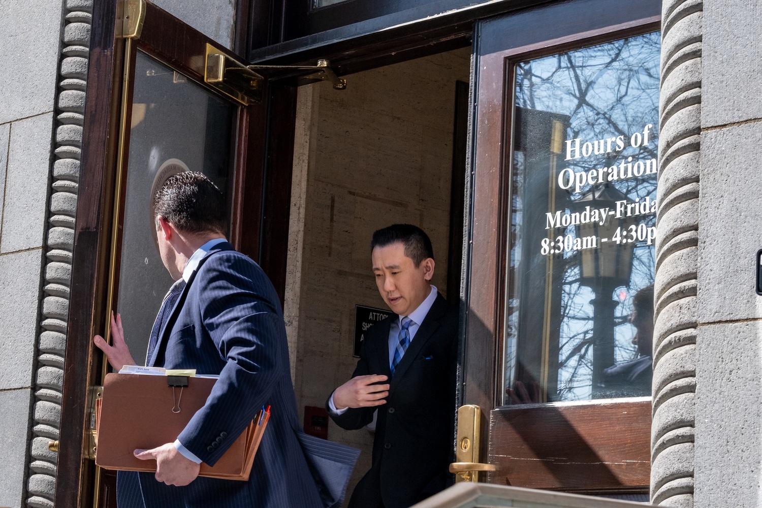 Jason Z. Han (right), one of two defendants present at Friday’s hearing, exited the courthouse with lawyer John D. Pensa (left) after being criminally charged. Han’s arraignment is scheduled for May 16.