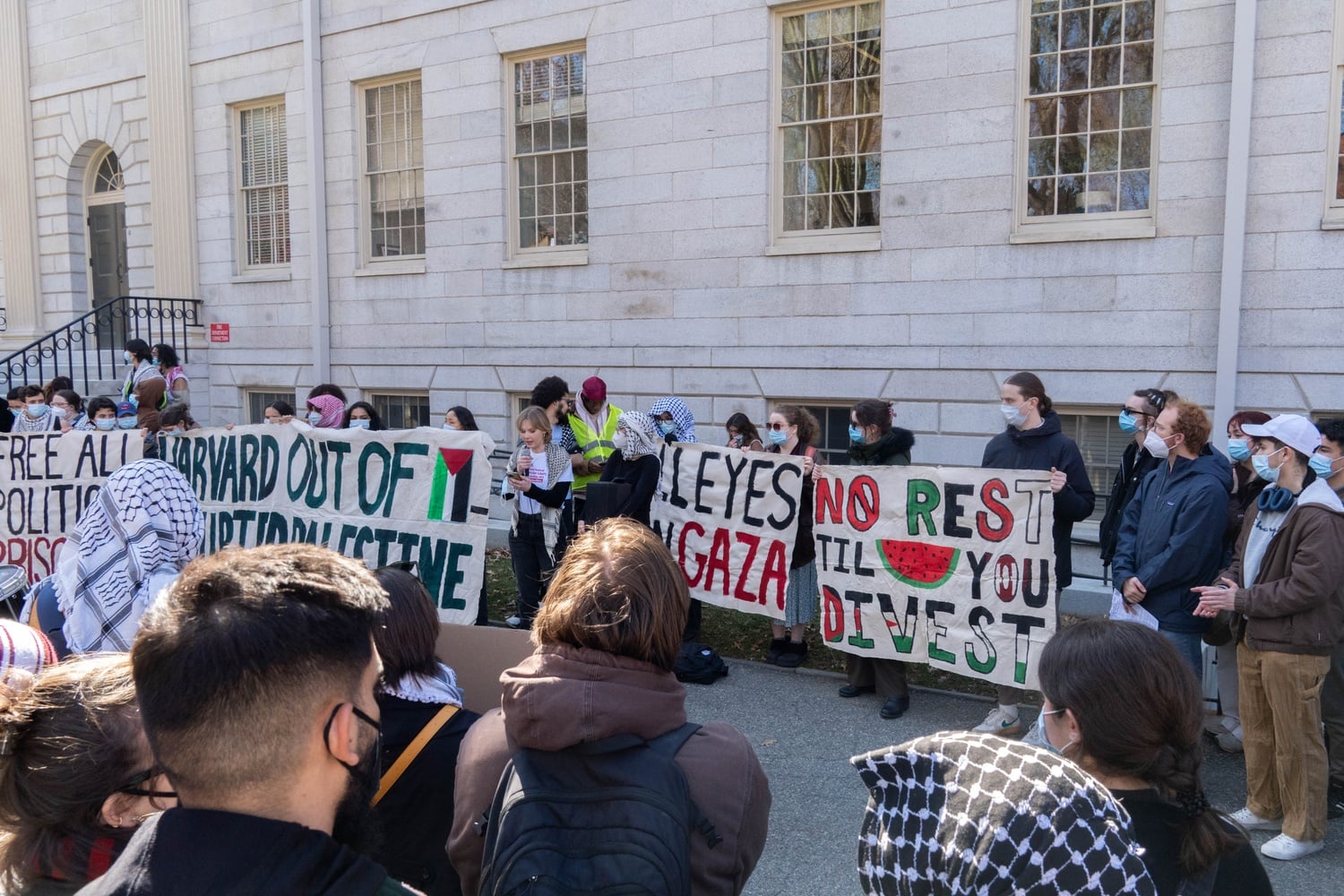Dozens of Harvard affiliates gathered outside University Hall for a rally organized by Harvard Out of Occupied Palestine.