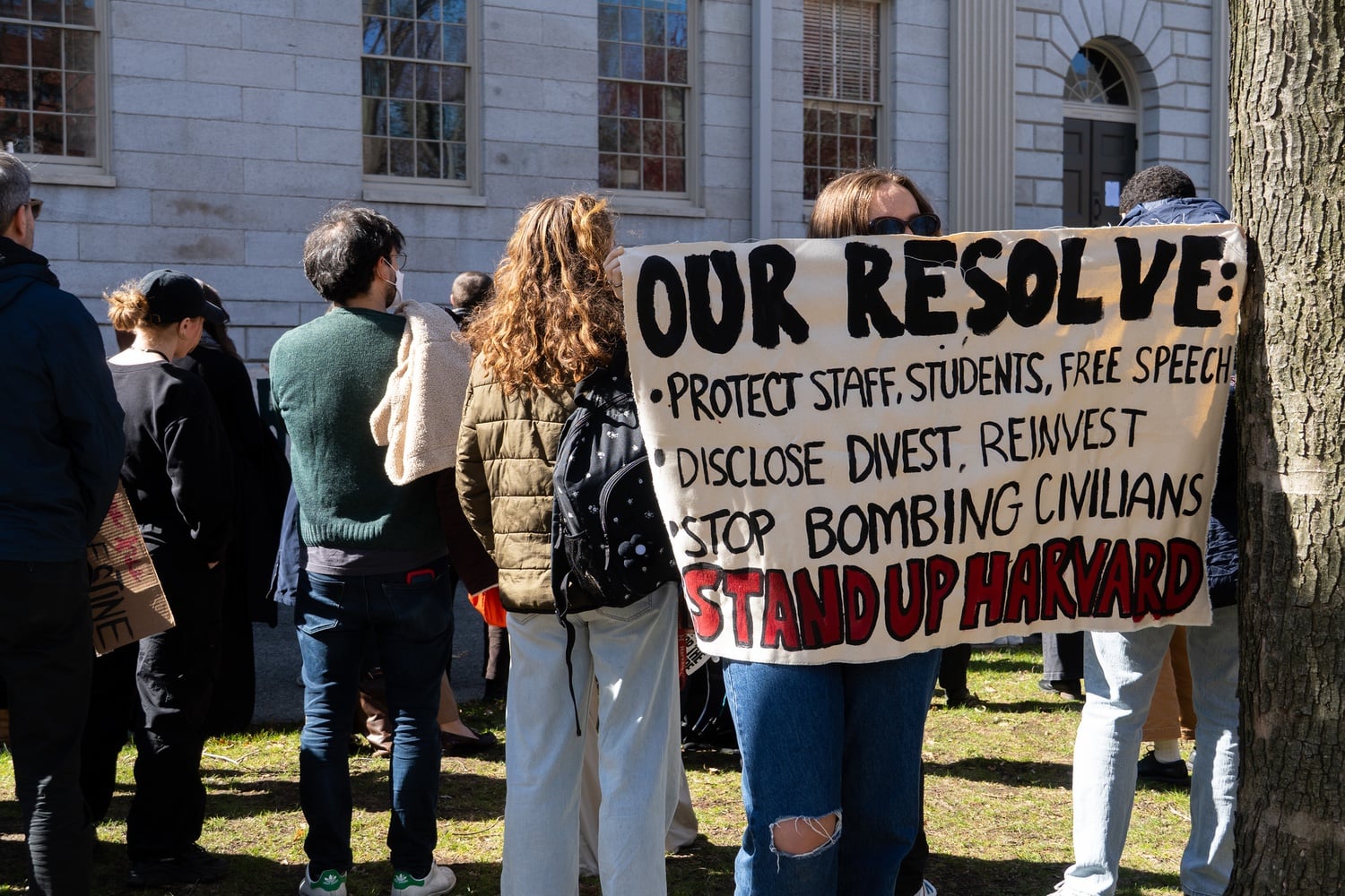 Protesters hold a banner at an April 1 Harvard Out of Occupied Palestine rally outside of University Hall. The Harvard Undergraduate Palestine Solidarity Committee was placed on probation for actions at the rally, which was advertised by groups including the PSC.