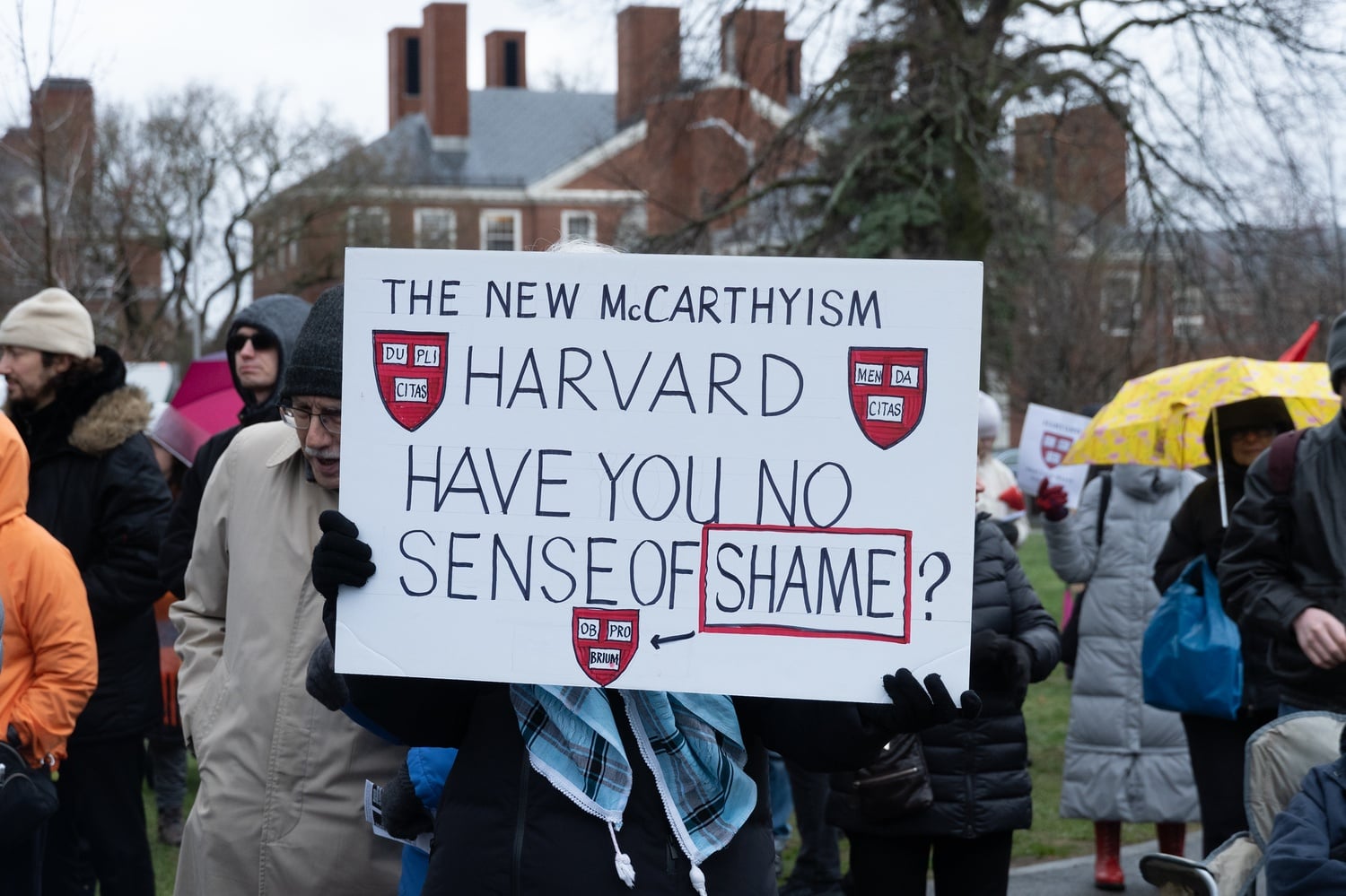 A demonstrator at Saturday’s rally holds a sign decrying “the new McCarthyism” and asking Harvard, “have you no sense of shame?”