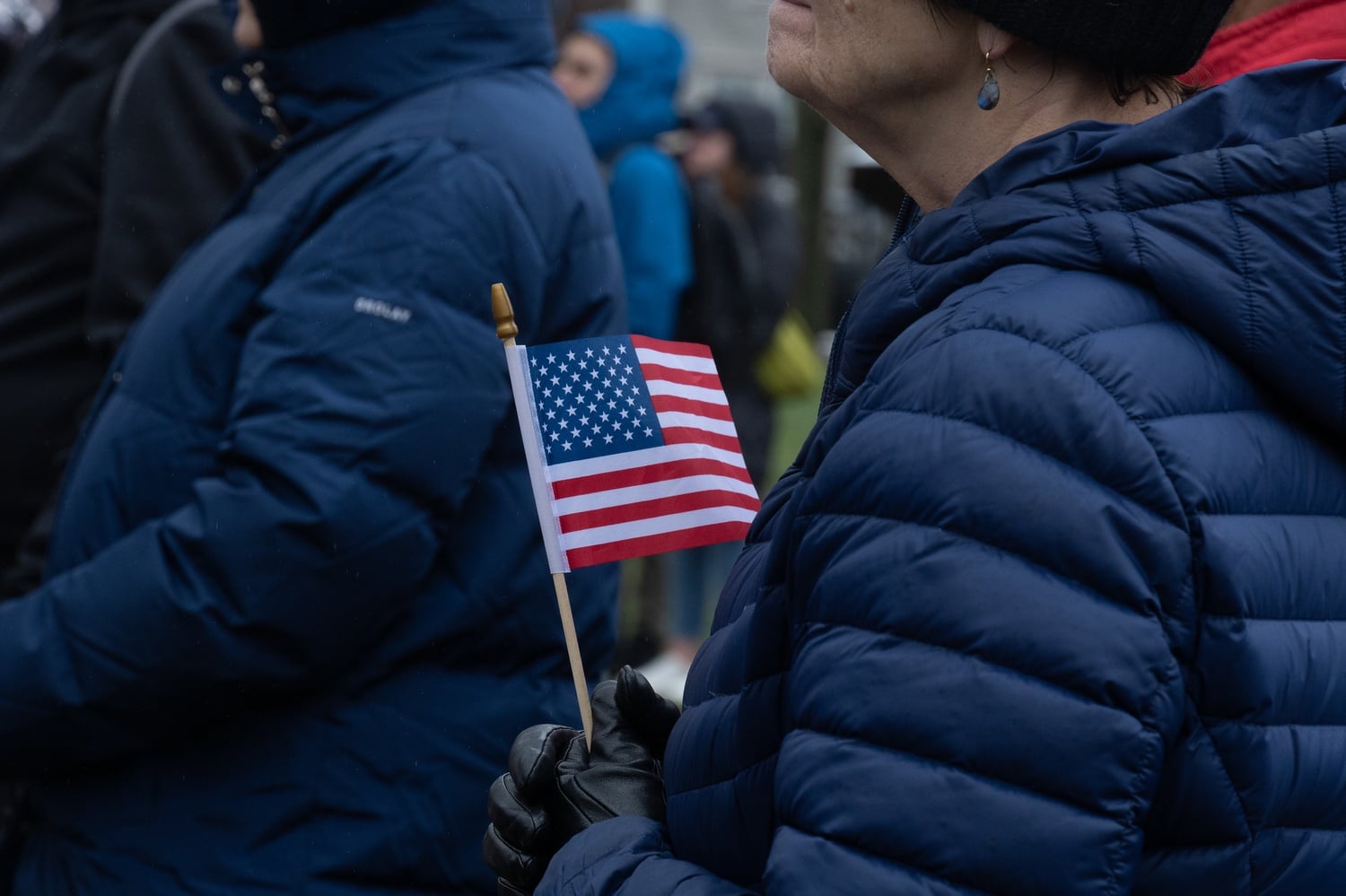 A protester at Saturday’s rally holds an American flag. The rally was held by the Cambridge City Council and Harvard’s chapter of the American Association of University Professors, as well as the 50501 movement, which has organized anti-Trump demonstrations nationwide.