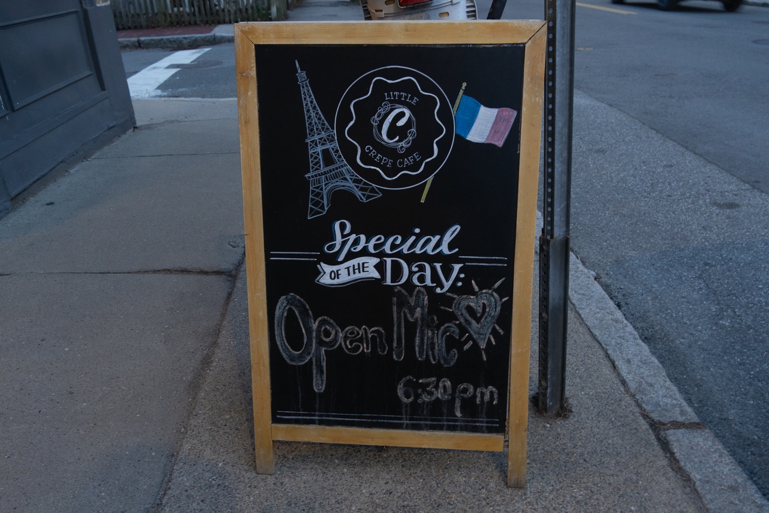 A sign for an open mic at the Little Crêpe Café.