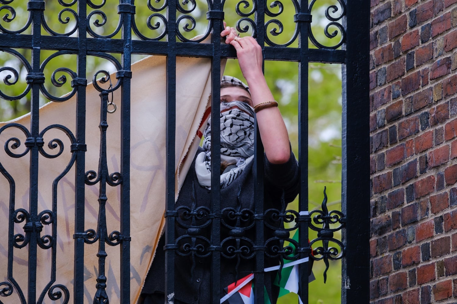 A protester used zip ties to fasten a banner onto Johnston Gate on Saturday.