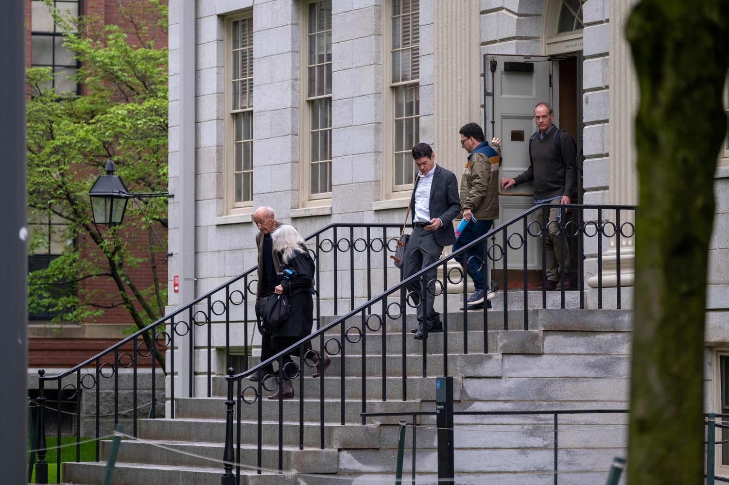 Harvard faculty members exit University Hall after a Faculty of Arts and Sciences meeting Tuesday afternoon. At the meeting, FAS Dean Hopi E. Hoekstra told faculty that the Trump administration's cuts to Harvard's funding would not be easy to reverse.