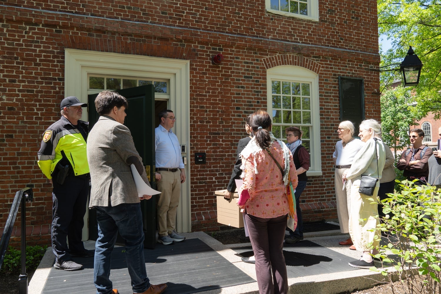 Harvard affiliates deliver a box of complaints alleging a hostile climate for Muslim, Arab, and Palestinian students to a University employee outside Massachusetts Hall.