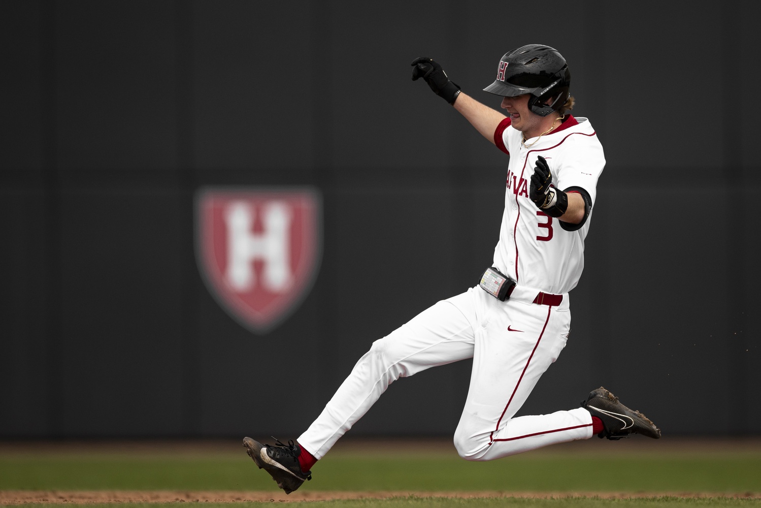 Ryan Mooney slides to second base during a baseball game in the spring. In the fall, he wears a football helmet for the Crimson.