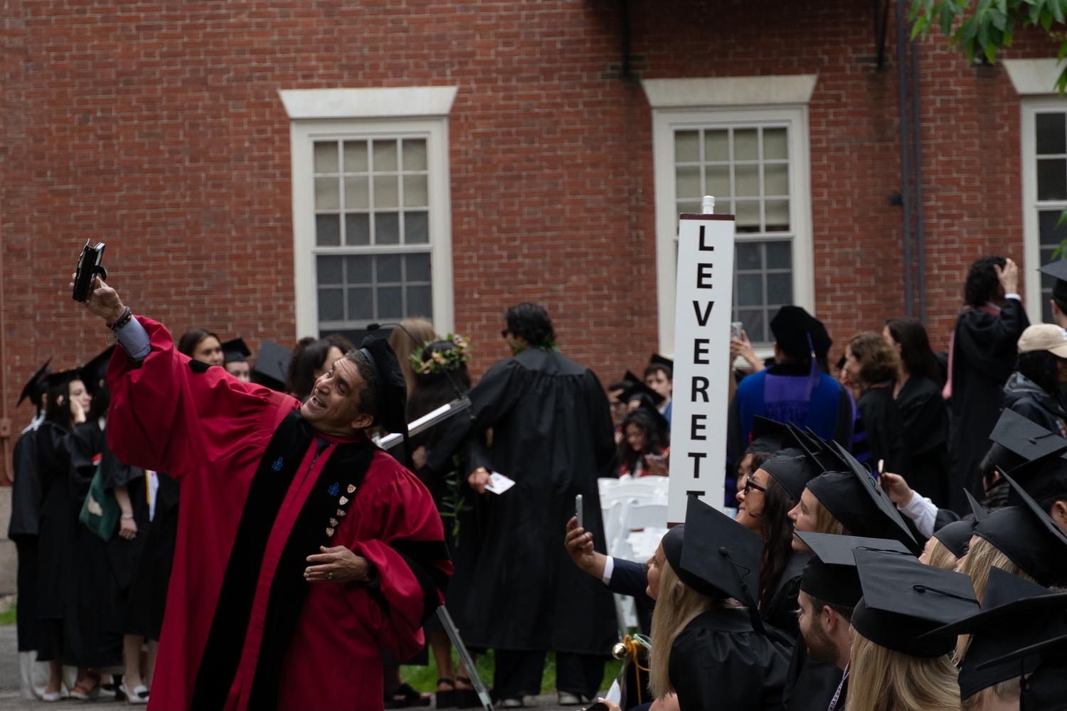 Dean Rakesh Khurana poses with students for a selfie during the Commencement day ceremonies.