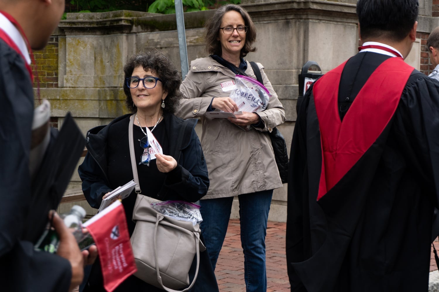 Members of the alumni group Crimson Courage hand out fliers outside Harvard's May 2025 Commencement ceremony. On Monday, the group sent letters to Harvard's leaders, urging them not to sacrifice academic freedom in talks with the White House.