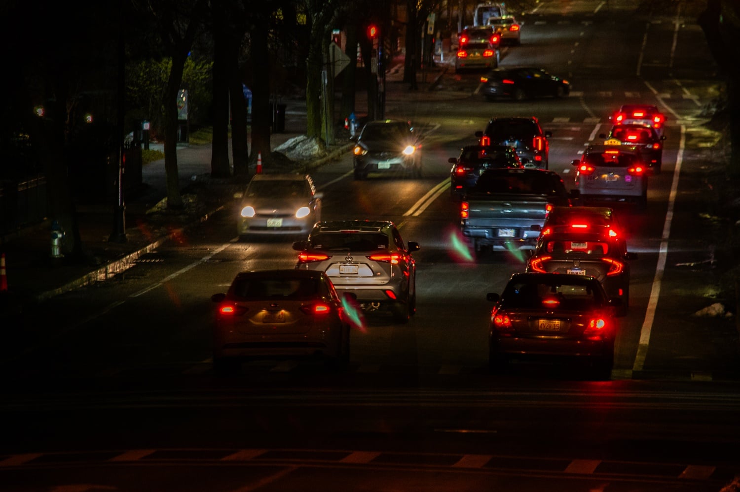 Vehicles drive near the Anderson Memorial Bridge at night.