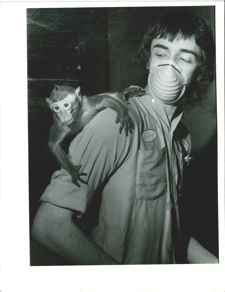A worker at the NEPRC poses with a primate on his back.