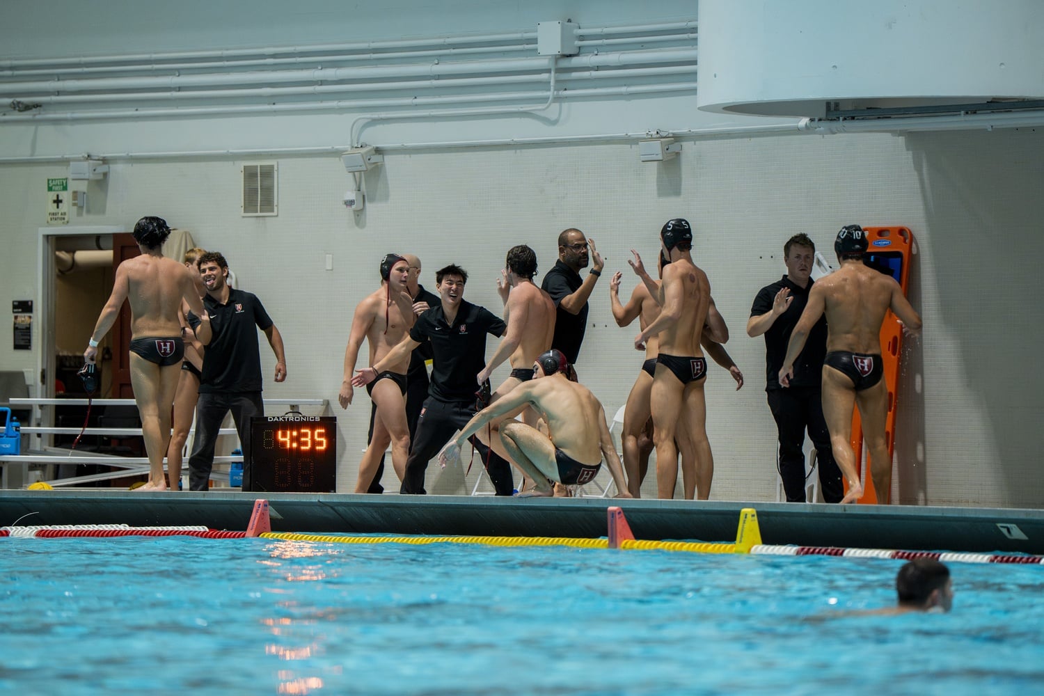 Members of the Harvard men's water polo team high-five after a win against Brown to start November.