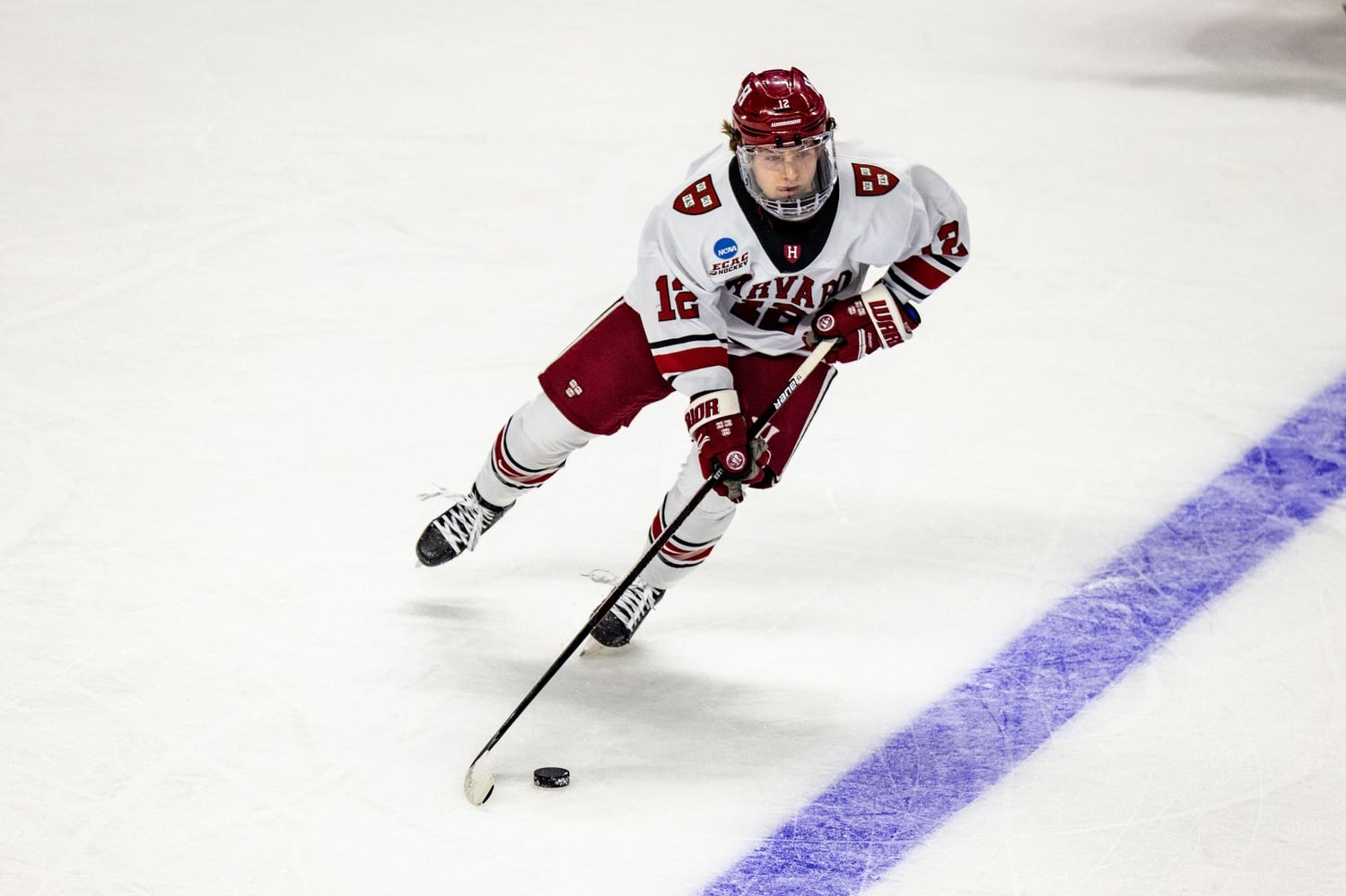 Joe Miller skates with the puck during the men's ice hockey team's NCAA Tournament first-round game against Ohio State in 2023.