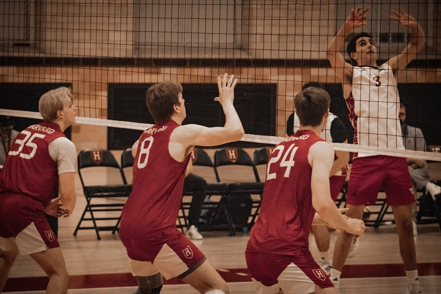 Junior middle Owen Woolbert, captain Brian Thomas, and sophomore opposite Sawyer Nichols block for Harvard at the net.