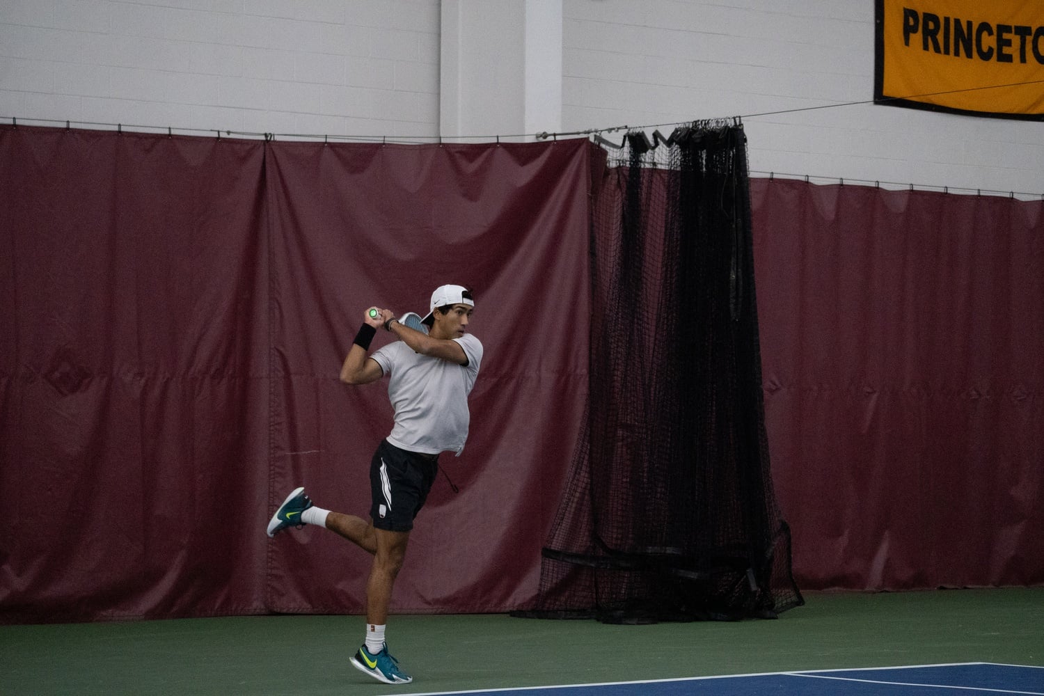 Senior Masato Perera hits a shot against Boston University.