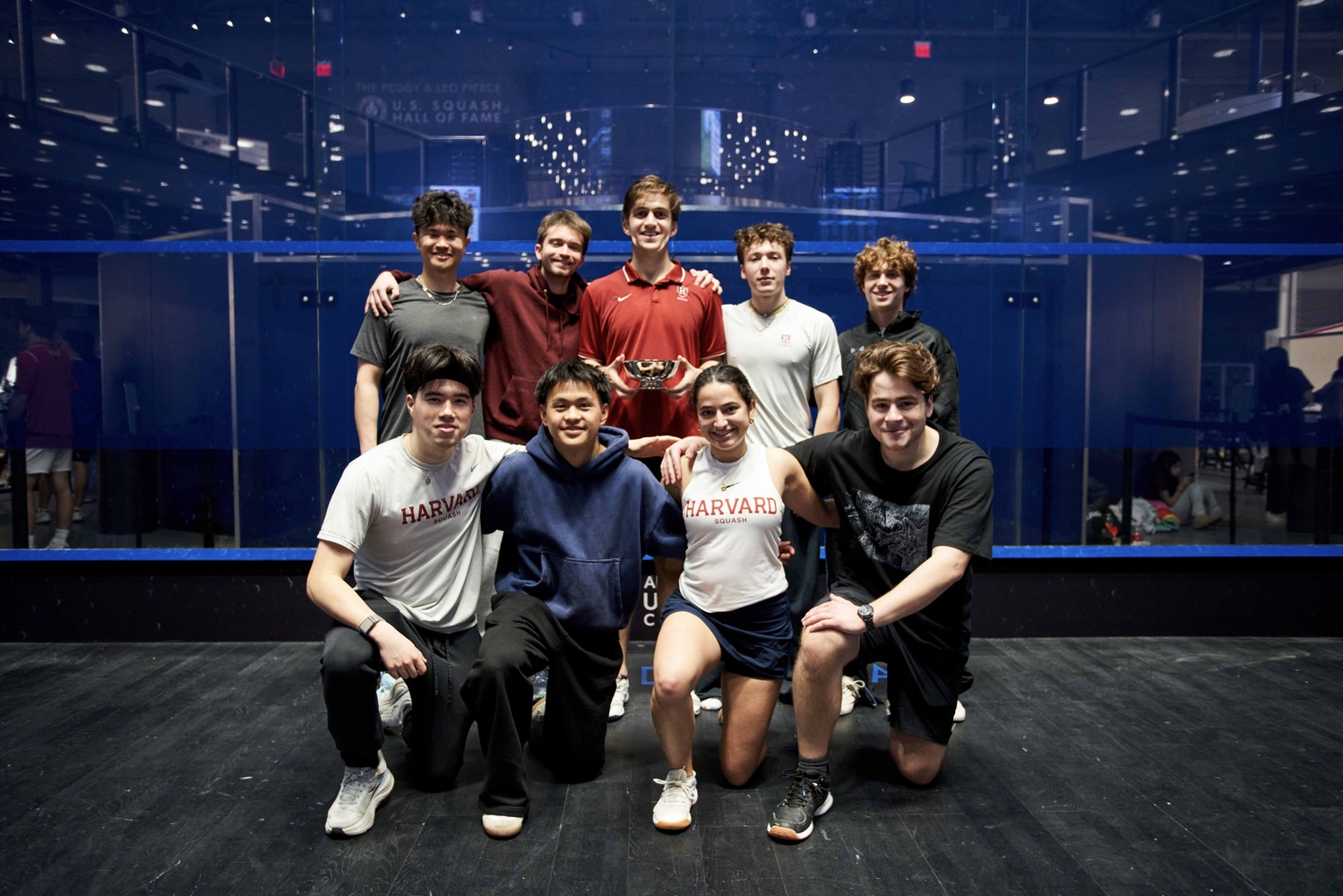 The victorious Harvard Club Squash team posing after their championship with captain Daniel Hochberg holding the Hawthorn Cup