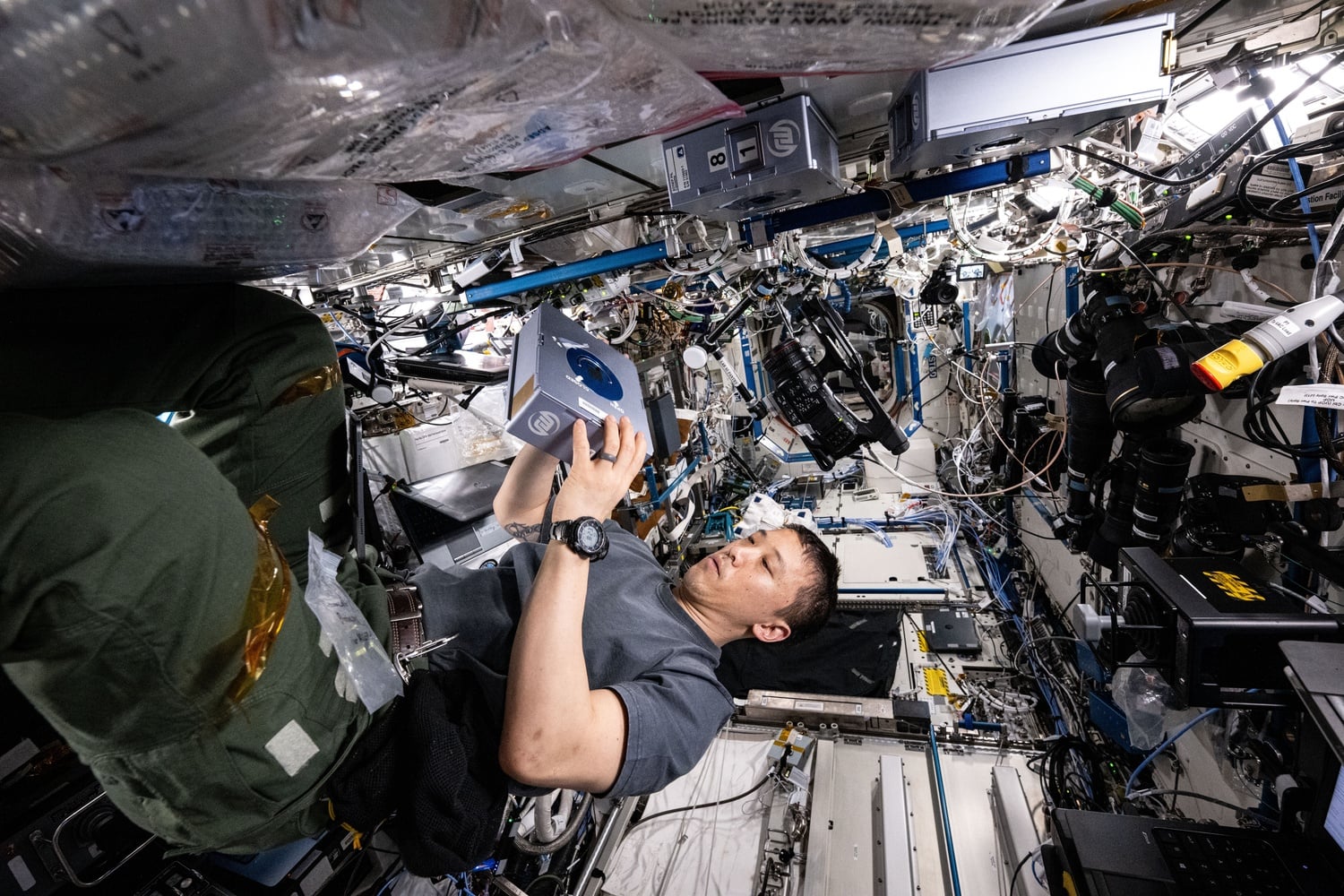 NASA astronaut Jonny Kim services a sample processor for a pharmaceutical investigation in August 2025.