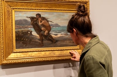 Cover image for Allison K. Jackson examining an artwork's frame