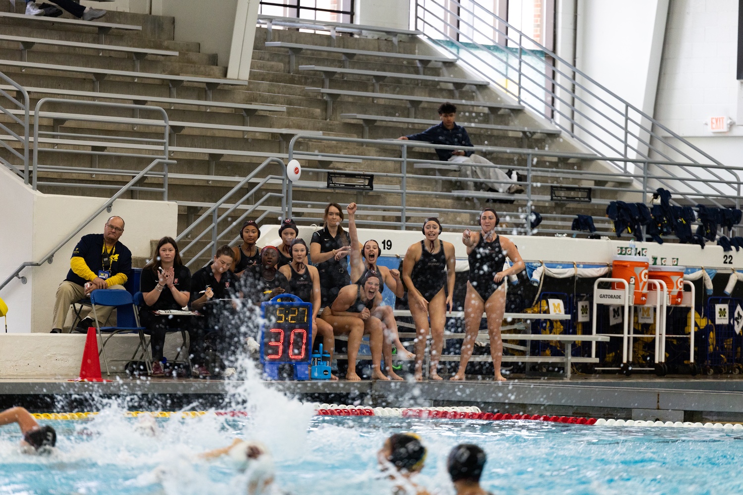 The Harvard women's water polo team erupts into cheers. 