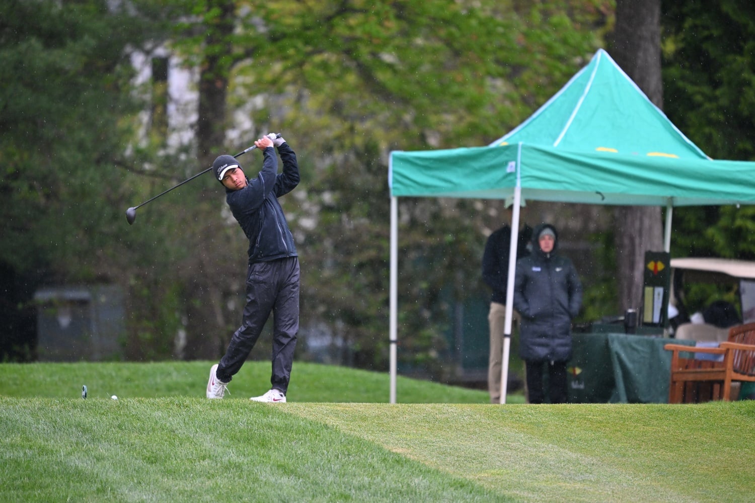 A Harvard golfer braves rainy weather during the 2026 Ivy League Championships. 
