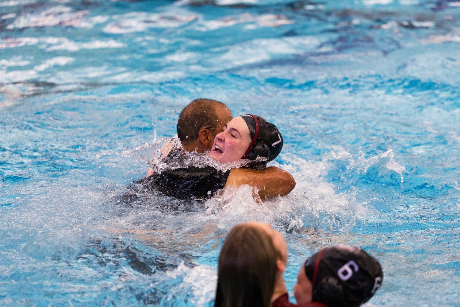 Coach Minnis celebrates in the water with Schneider after her game-winning goal.