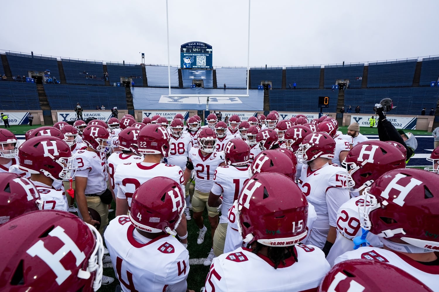 The Harvard football team huddles before the 2025 Harvard-Yale Game.