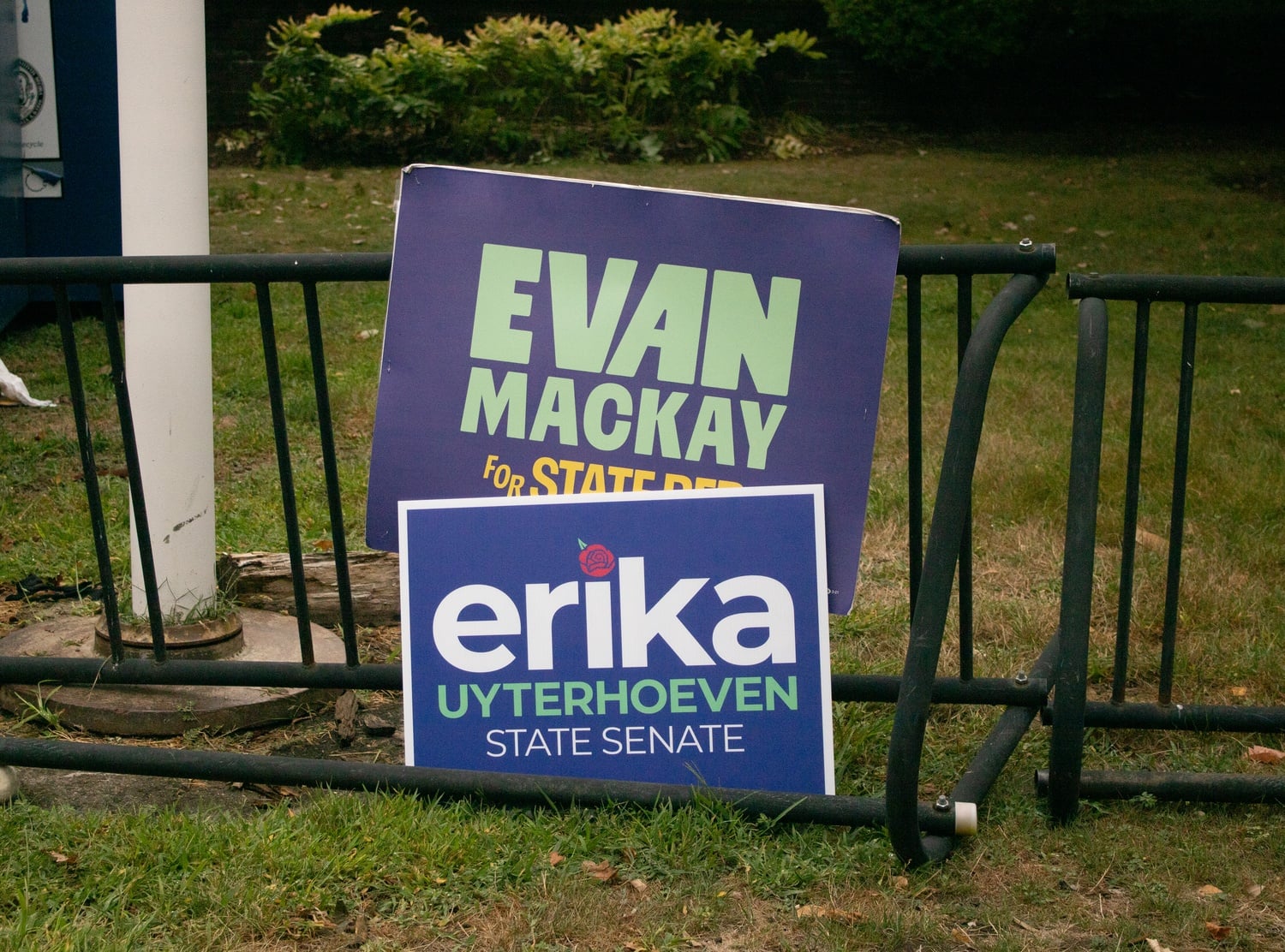 Campaign signs for Evan C. MacKay '19 and Erika Uyterhoeven sit outside a polling place on Tuesday. Both candidates are running in contested Democratic primaries.