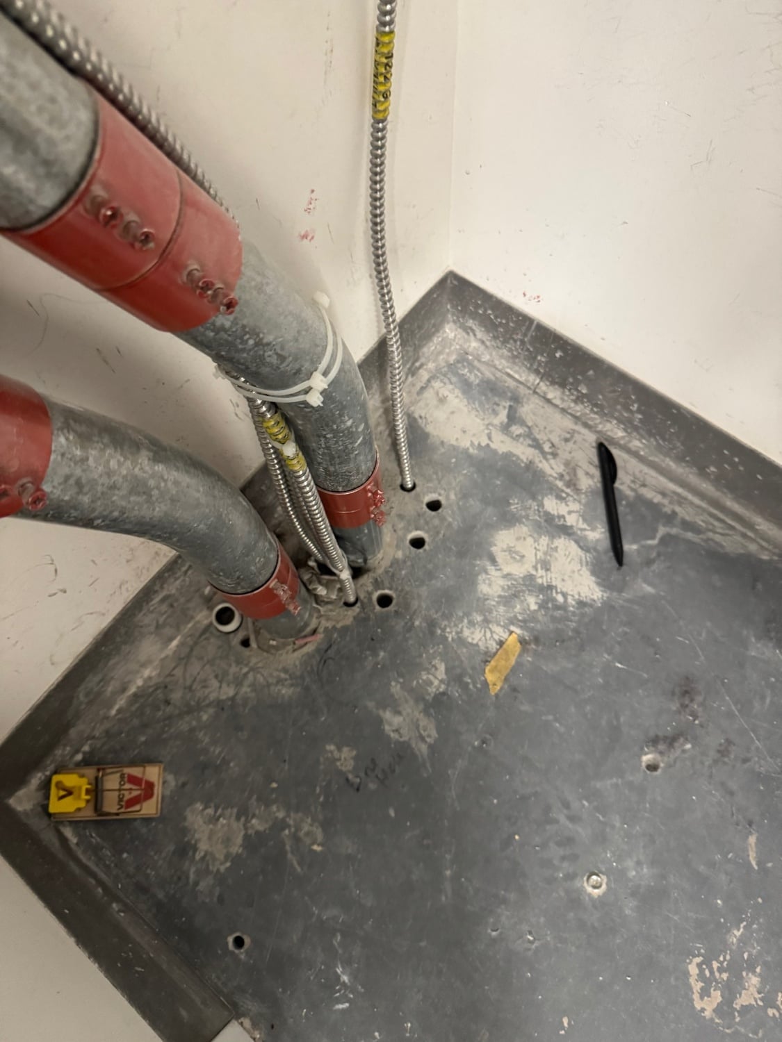 Floor penetrations from work by DPM Design and Construction in Taubman 3CL10 lacked fire-stop sealant around electrical conduits on July 23, 2025.