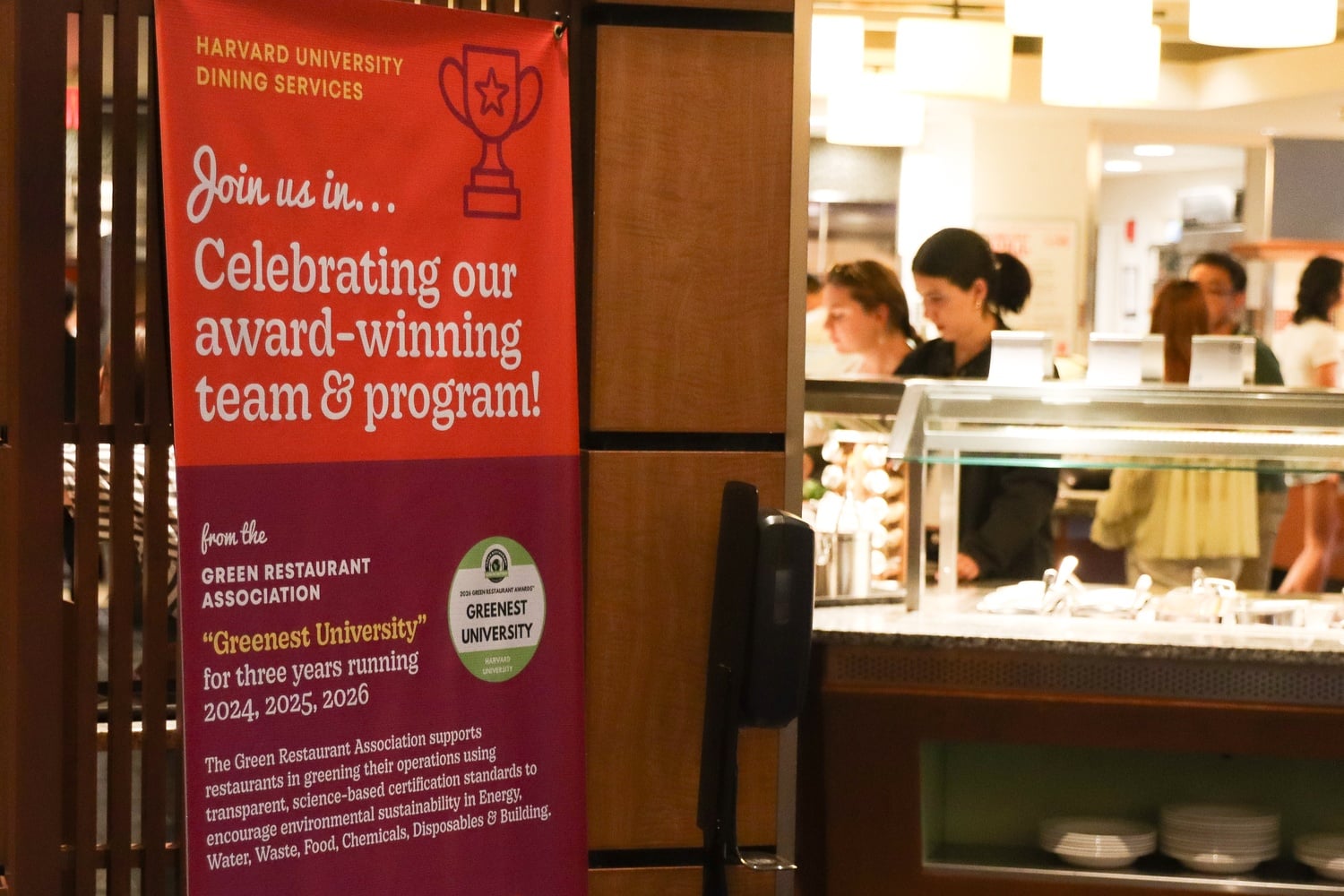 A sign describing the Greenest University award at the Quincy House dining hall.
